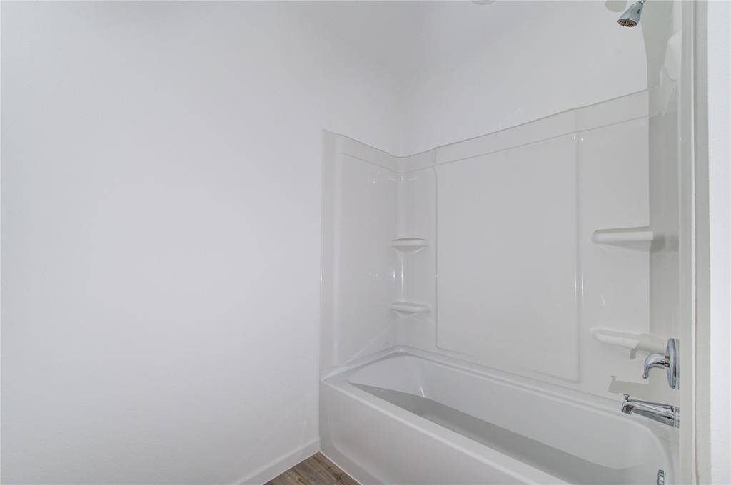 The tub is equipped with a wall-mounted showerhead