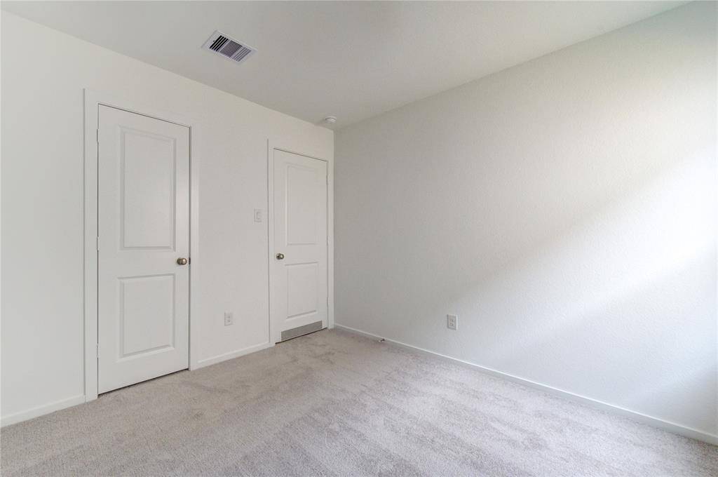 Bright, carpeted bedroom with a large window