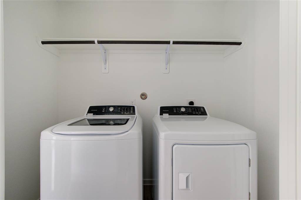 Compact laundry nook with a washer, dryer, and overhead shelf