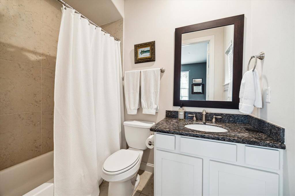 The first floor en-suite bathroom boasts a large tub/shower, a granite vanity and brushed nickel hardware.