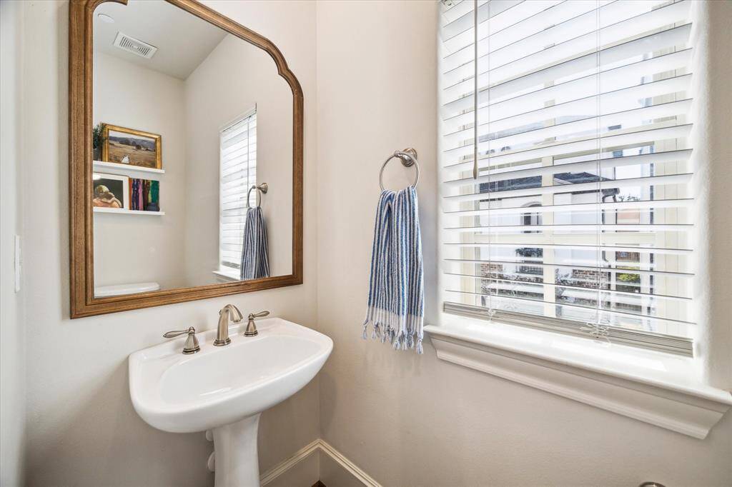 A windowed powder room with a pedestal sink completes the second level.