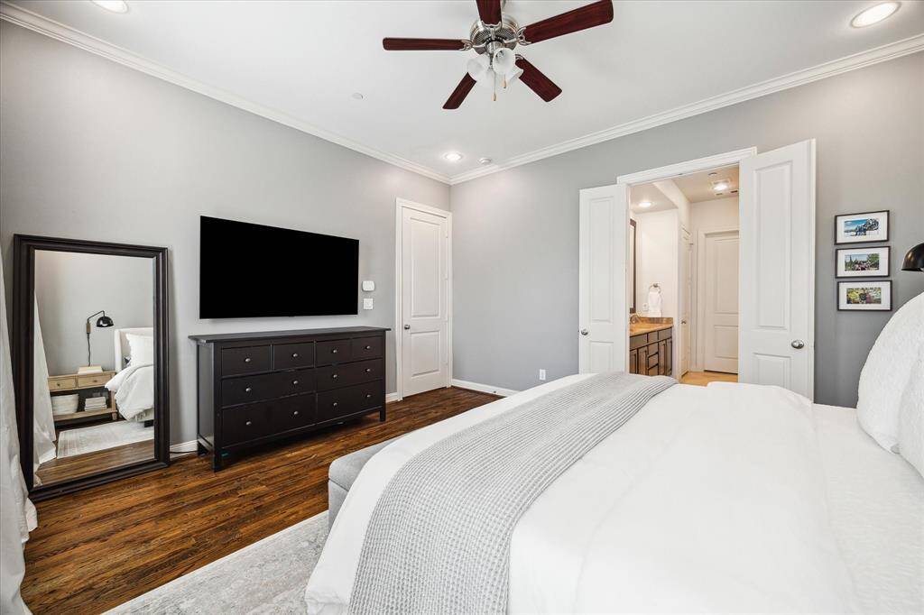 A/V connections and a ceiling fan add comfort and convenience to the tranquil primary bedroom, while double doors open to the en suite bathroom.