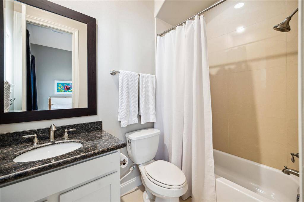 The third-floor en suite secondary bathroom includes a large tub/shower and roomy granite vanity.