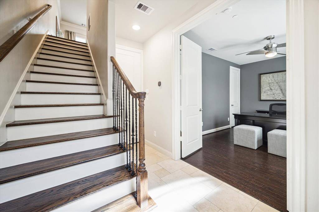 A handsome staircase trimmed with an iron and wood handrail leads to the main entertaining level, while French doors open to a secondary suite ideal for home office or guest use.