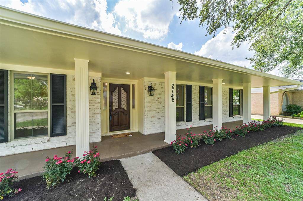 Newly planted rose bushes line the freshly painted front porch welcoming you home.