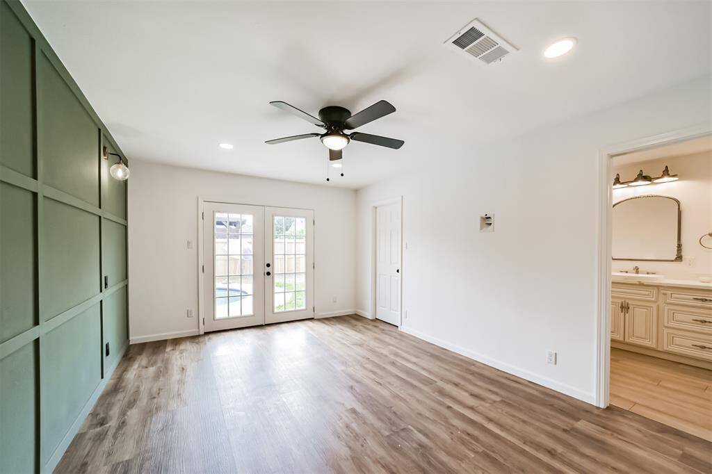 Bedroom 4, the Primary Suite features french doors leading to the pool and backyard