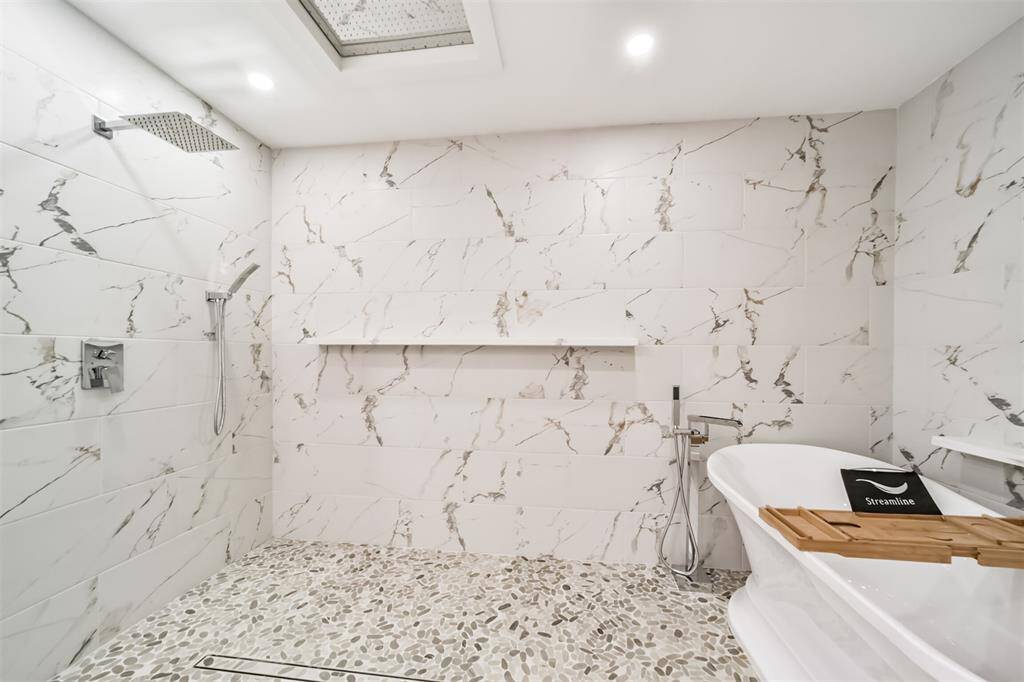 This beautiful spa like shower features an overhead rain showerhead as well as showerhead and hand held spout.