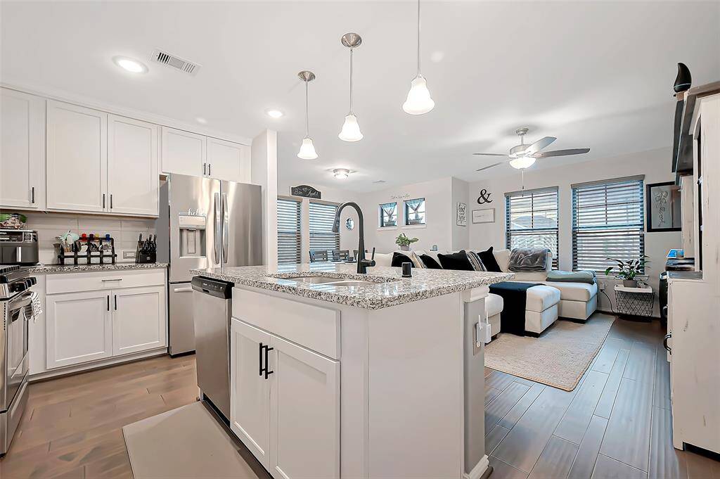 Open-concept kitchen with granite countertops, stainless steel appliances, and a center island with breakfast bar.