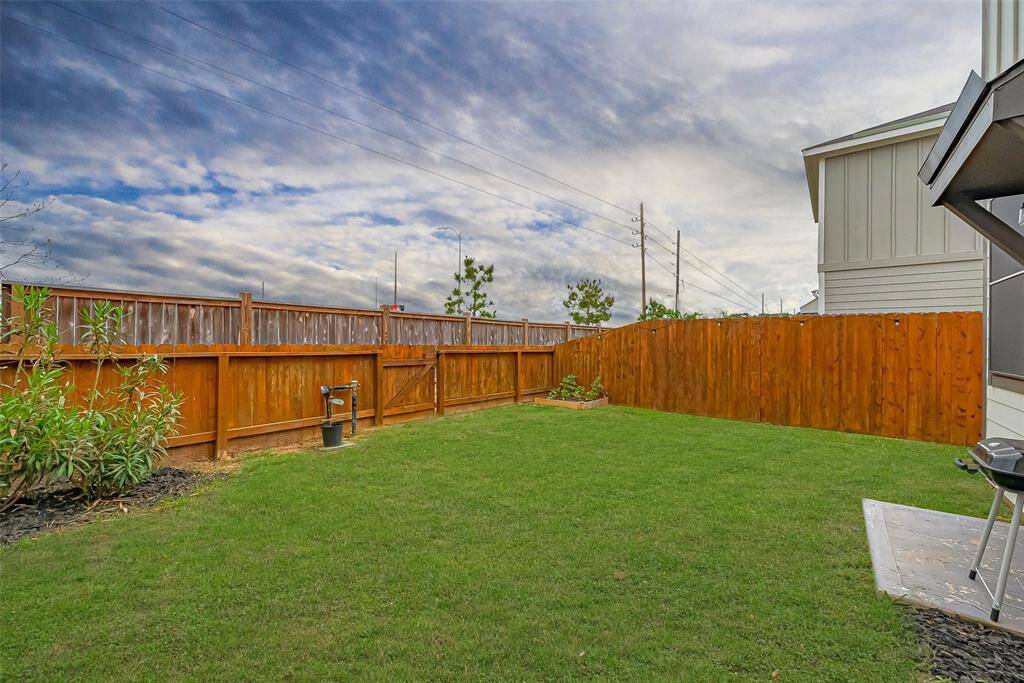 Private fenced backyard with lush green space — ideal for pets, play, and outdoor entertaining.