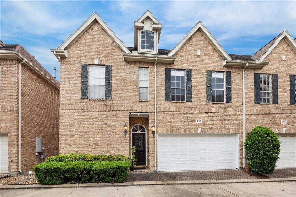 Impressive brick exterior with classic curb appeal, spacious driveway, and a two-car garage in a beautifully maintained setting