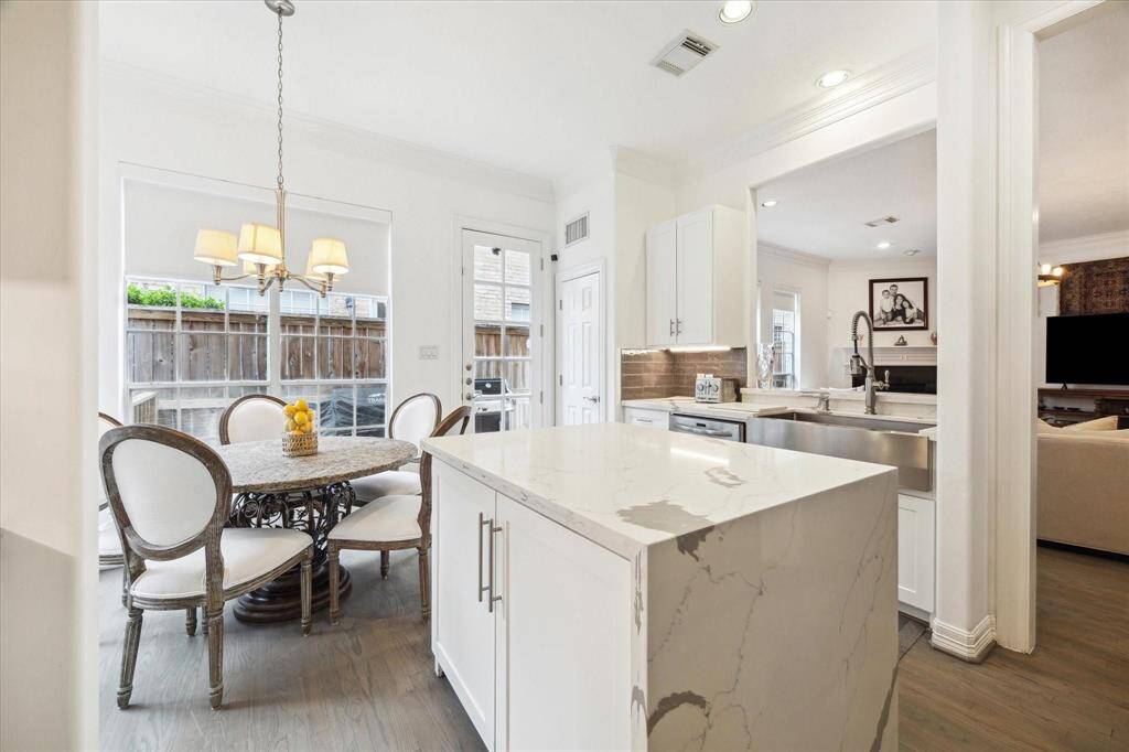 Open-concept kitchen with a large center island, stylish pendant lighting, and direct access to the breakfast and dining areas
