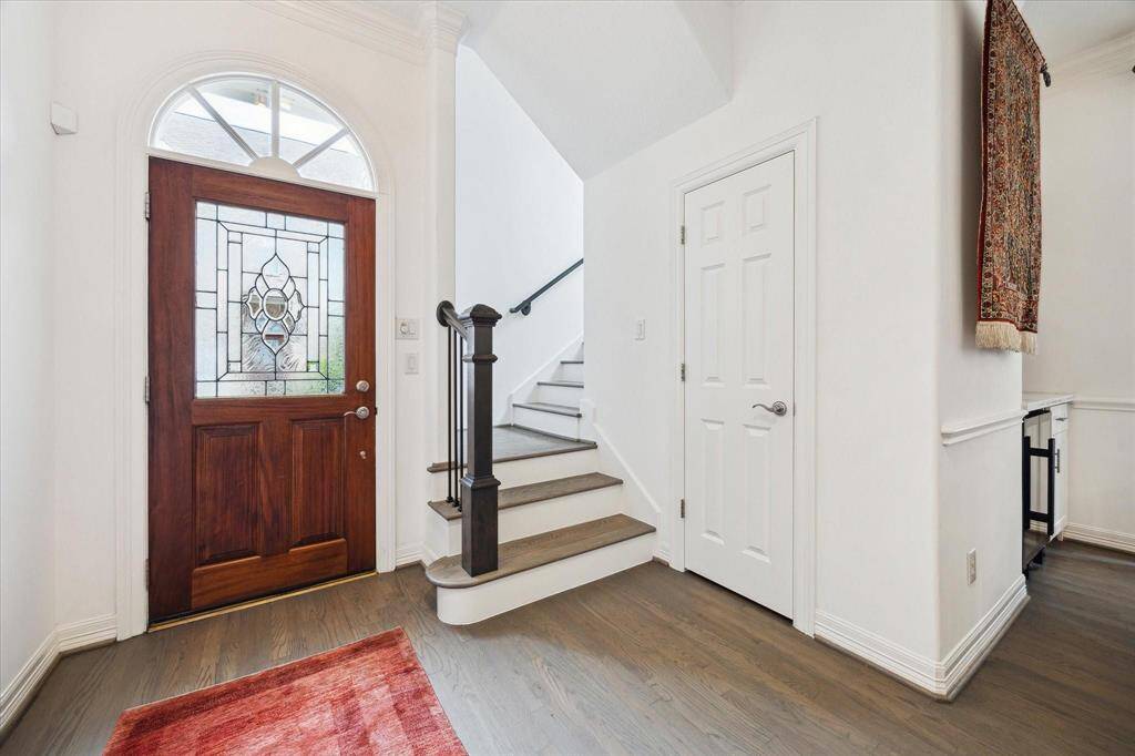 Bright and inviting entryway featuring soaring ceilings, natural light, and a warm first impression with wood flooring and elegant details.