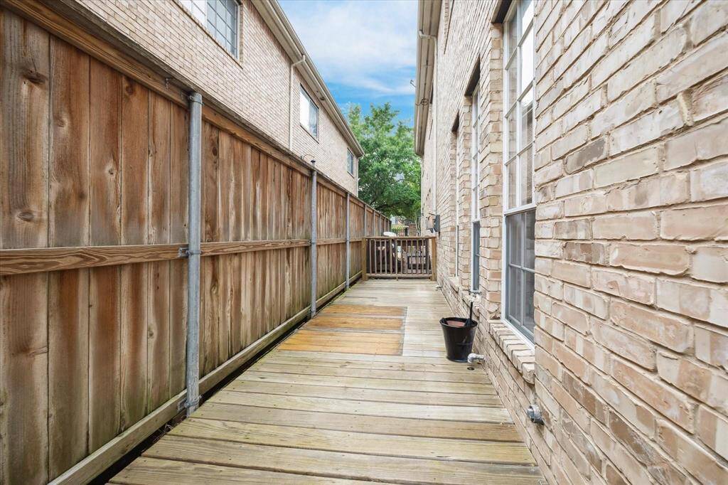 Spacious and low-maintenance side yard with a wood deck path—great for additional outdoor storage, play space, or a quiet retreat.