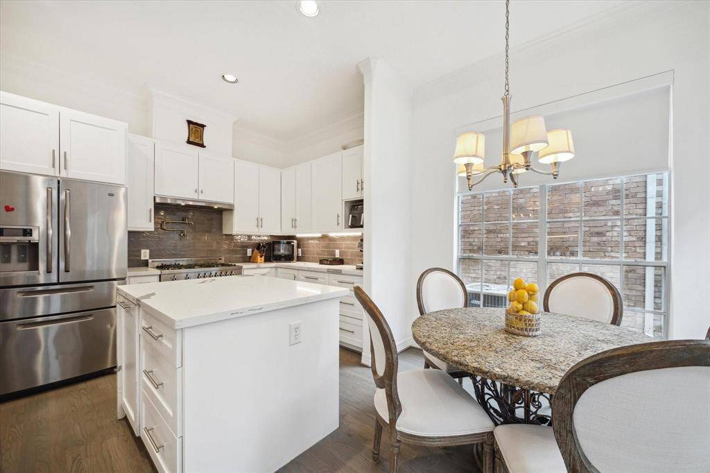 Bright and stylish kitchen with white cabinetry, granite countertops, stainless steel appliances, and a large island—plus a highly desirable pot filler faucet for added convenience. Opens seamlessly to the cozy breakfast area filled with natural light