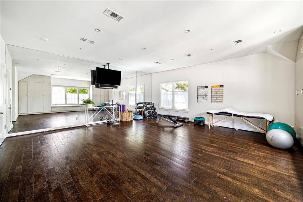Spacious and versatile, this flex room is currently outfitted as a full-scale exercise studio complete with mirrored walls, built-in storage, and hardwood floors. With abundant natural light and ample square footage, it easily adapts to fit your lifestyle needs—whether gym, studio, or playroom.