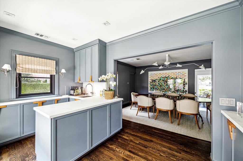 This stylish corner of the kitchen features sleek cabinetry, stone countertops, and a dedicated bar area—ideal for effortless entertaining. With a seamless connection to the dining room, it blends function and design in perfect harmony.