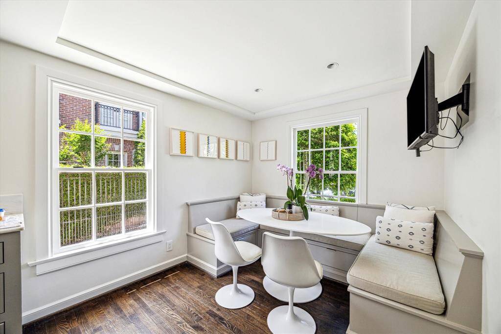 Flooded with natural light, the breakfast nook offers a cozy and cheerful setting for casual meals. Framed by oversized windows and built-in bench seating, it’s a charming corner designed for comfort and connection.