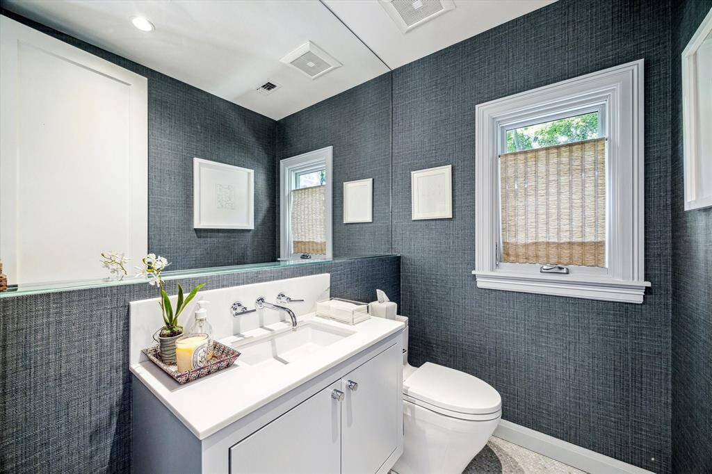 Wrapped in textured grasscloth wallpaper, this chic powder bath is both refined and functional. A floating mirror, sleek vanity, and polished fixtures complete the space with understated elegance.