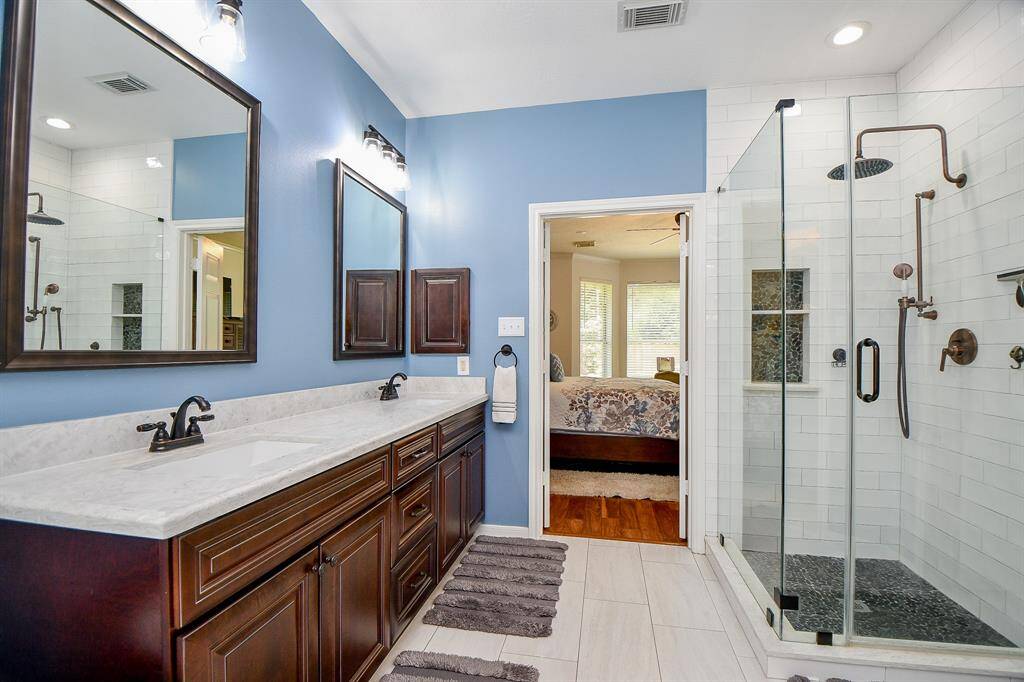 Soothing sky blue walls fill this peacefully relaxing primary ensuite bath; with dual sinks, tasteful individual mirrors and delicate lighting above, and tons of storage, below. The free standing oval tub is yours to enjoy any time of day or night under a lovely window.