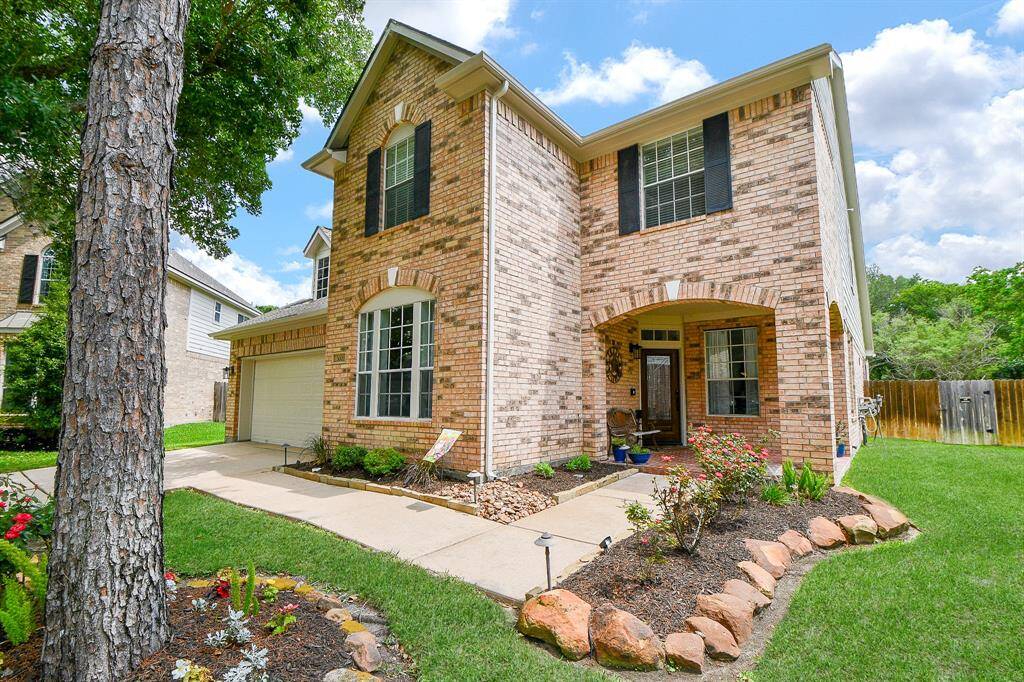 The pristine walkway to the covered front entry extends from the driveway.