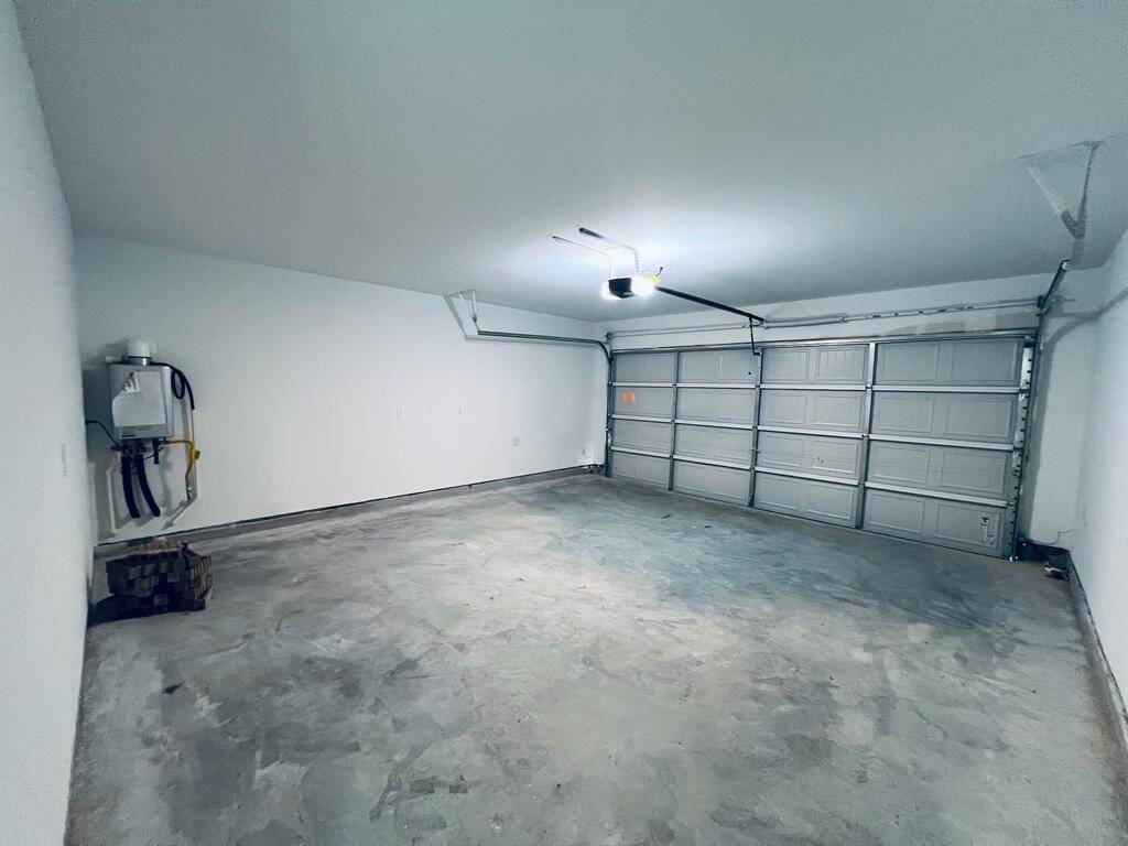 Garage includes remote garage door opener and tankless water heater