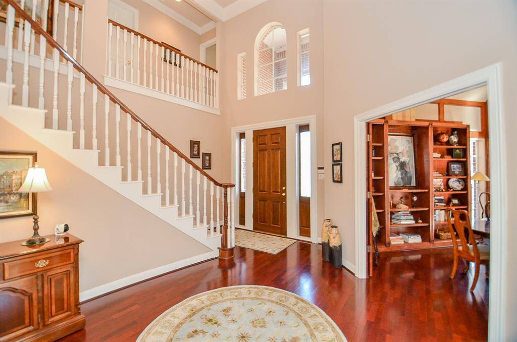 An entry with soaring ceilings, wood floors and triple crown molding!