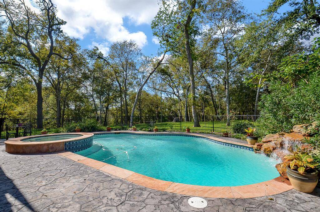 This gorgeous pool with a spa and rock waterfall is located off of the large covered back patio!