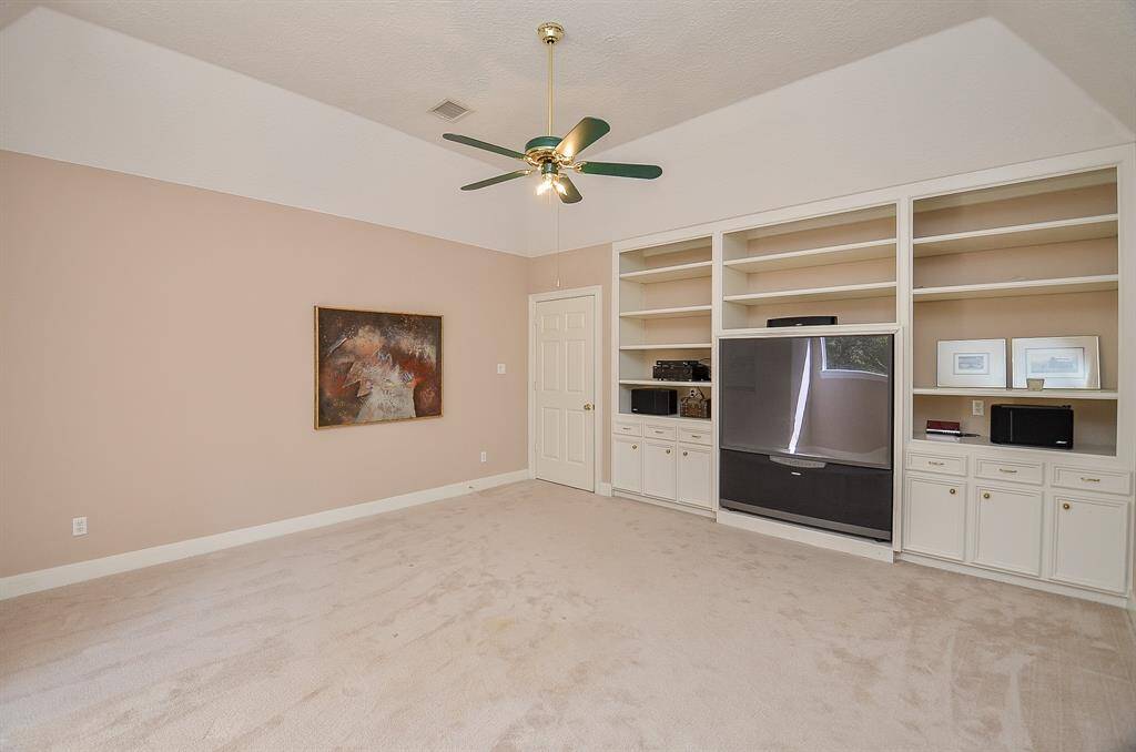 Game Room upstairs has a wall of built-in cabinets and shelves