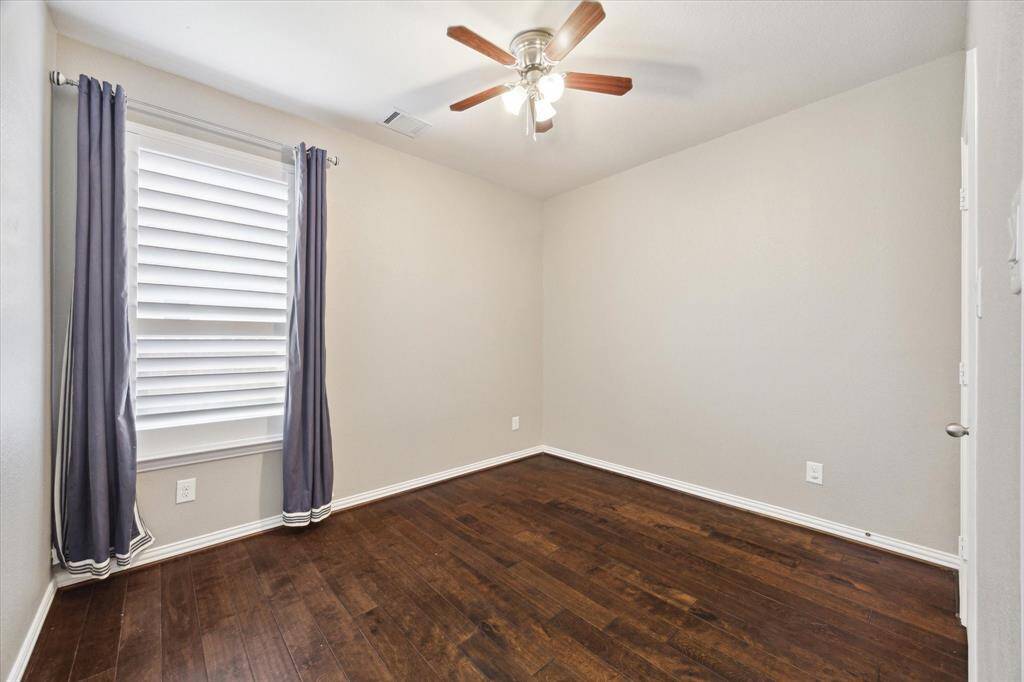 Another Bedroom (11x10) on first level. Great guest or flex space. Plantation shutters, neutral paint, hardwood flooring and decorative draperies. Full bath services this bedroom and is also a downstairs powder room.