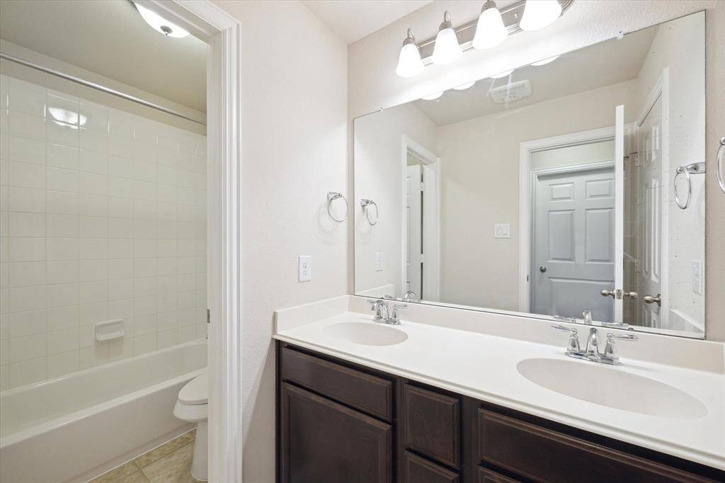 Shared bath for the two Secondary bedrooms upstairs. So functional with tub/shower, double sinks, stained cabinets and cultured marble countertops. Durable tile flooring.