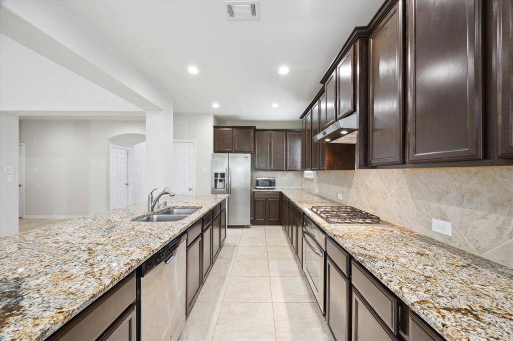 Kitchen (18x10) with loads of upper cabinets and counter space. Granite counters blend with the cabinets and stainless appliances. Gas cooktop and counter microwave. Under counter stainless sink with recently replaced brushed nickel faucet.