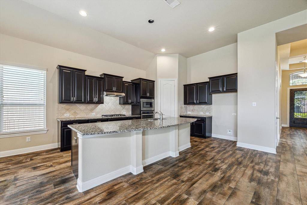 Expansive kitchen featuring a stylish eat-in island and a convenient walk-in pantry.