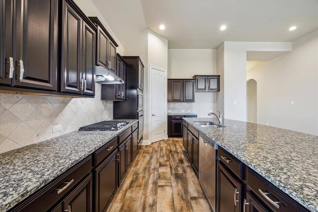 Experience elegance in this kitchen with its expansive granite countertops.
