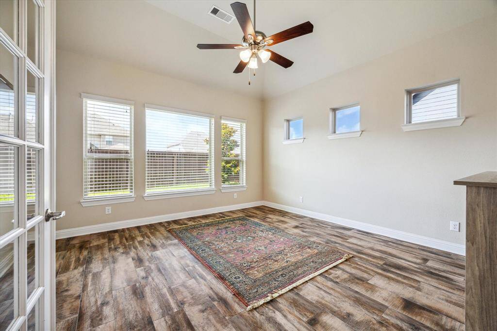 Versatile private room with elegant French doors, perfect for a home office, media, or exercise space.