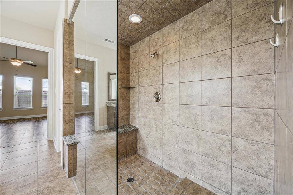 Indulge in a luxurious walk-in shower featuring a seamless design and convenient built-in bench.