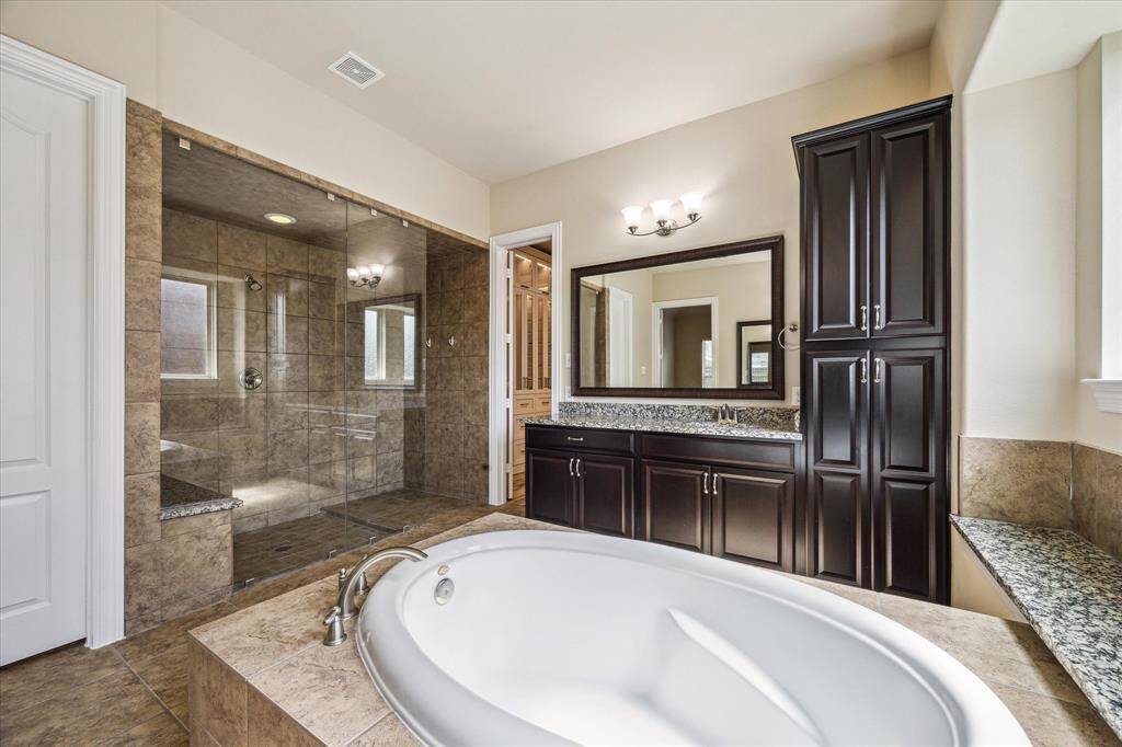 Experience the luxury of a walk-in shower, an elegant soaking tub, and convenient bench seating.