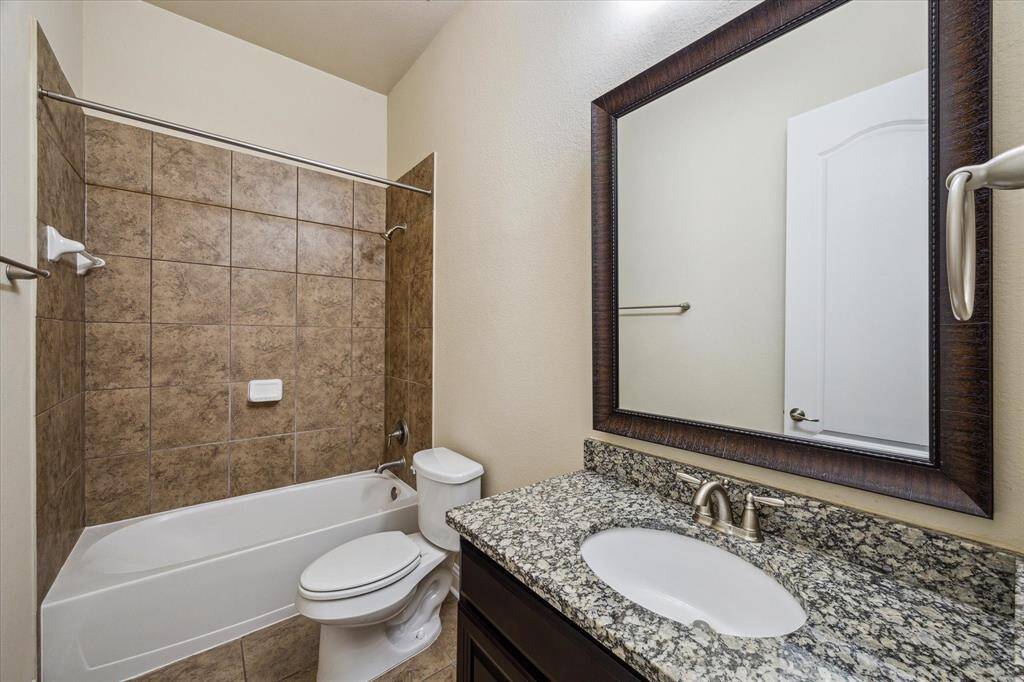Luxurious bathroom with a tiled tub, shower, and a granite vanity.