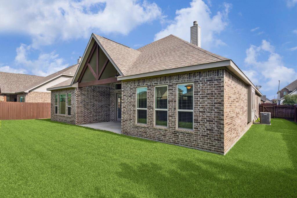 Covered patio with a view of a lush backyard—ideal for entertaining or a future pool.