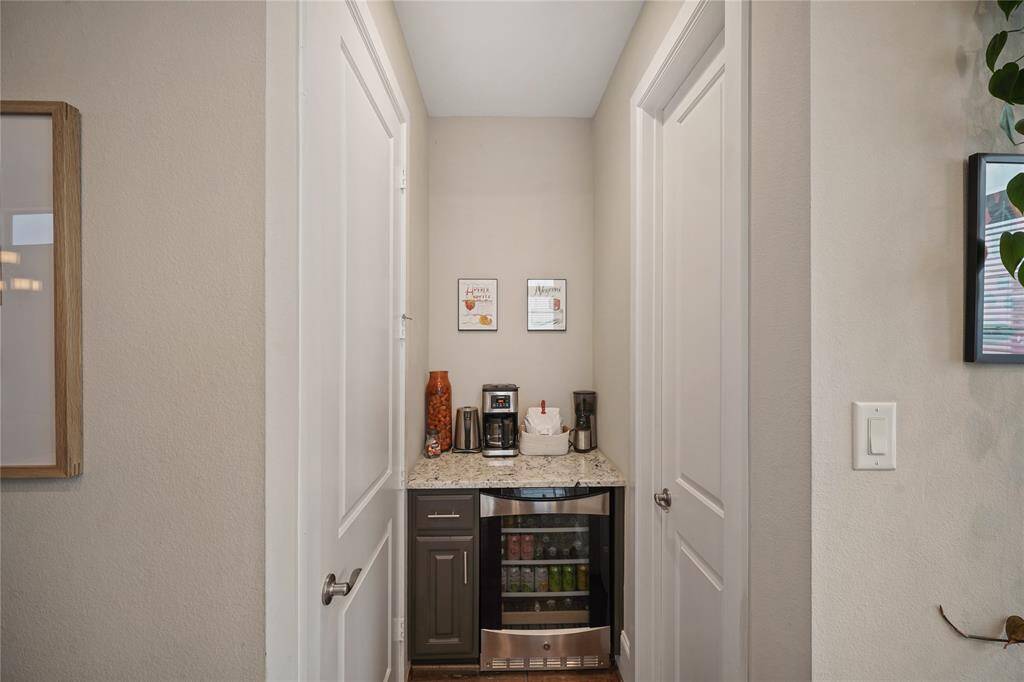 Coffee bar/dry bar located adjacent to the kitchen with laundry room on left and half bath on right.