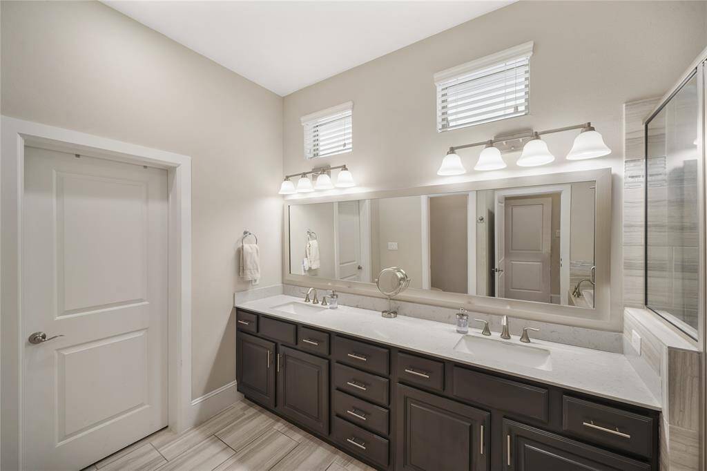 Double vanity and a generous walk-in closet, complemented by updated lighting, hardware, and sleek fixtures.