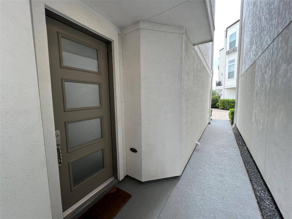 Sleek entryway with a stylish glass front door.