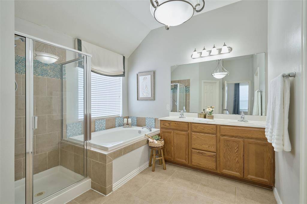 The primary bath is spacious and features two separate sinks, along with a tub and shower.