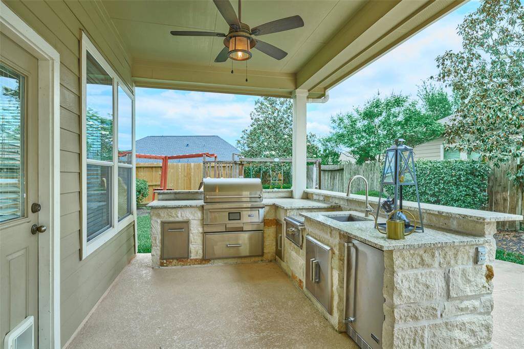 The custom-built kitchen is equipped with a pellet grill, gas stove, and refrigerator, making it perfect for family gatherings or entertaining.