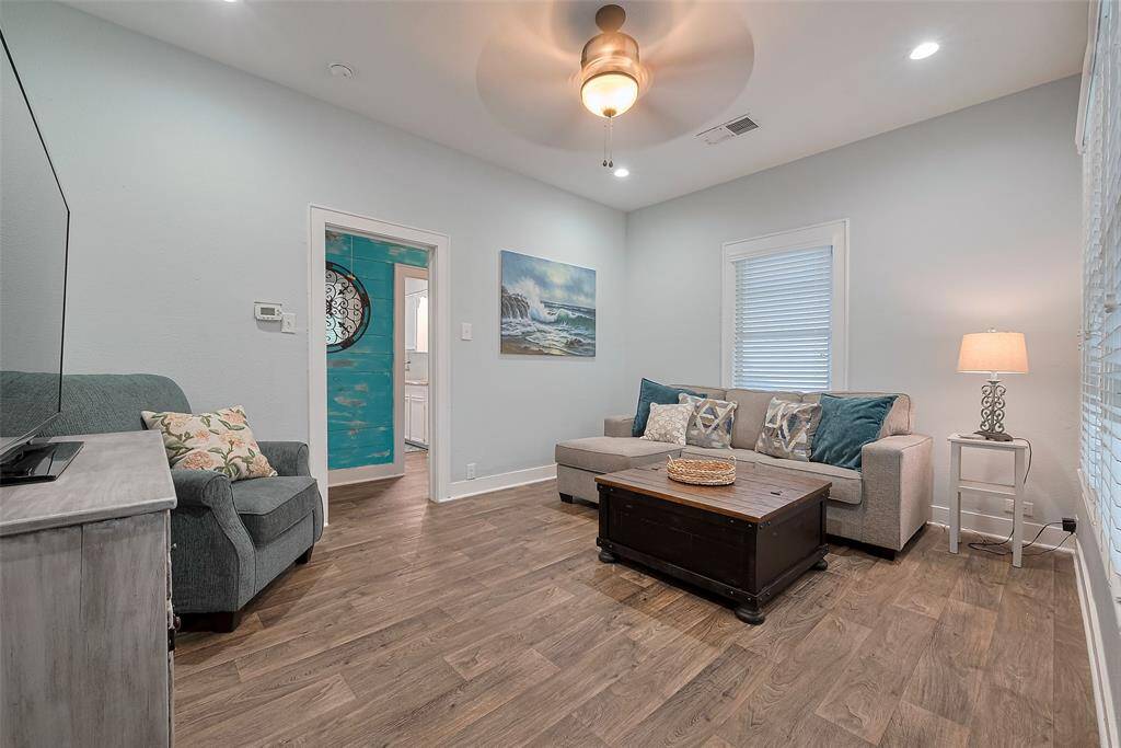 Cozy living room with light blue walls and wood-look flooring.