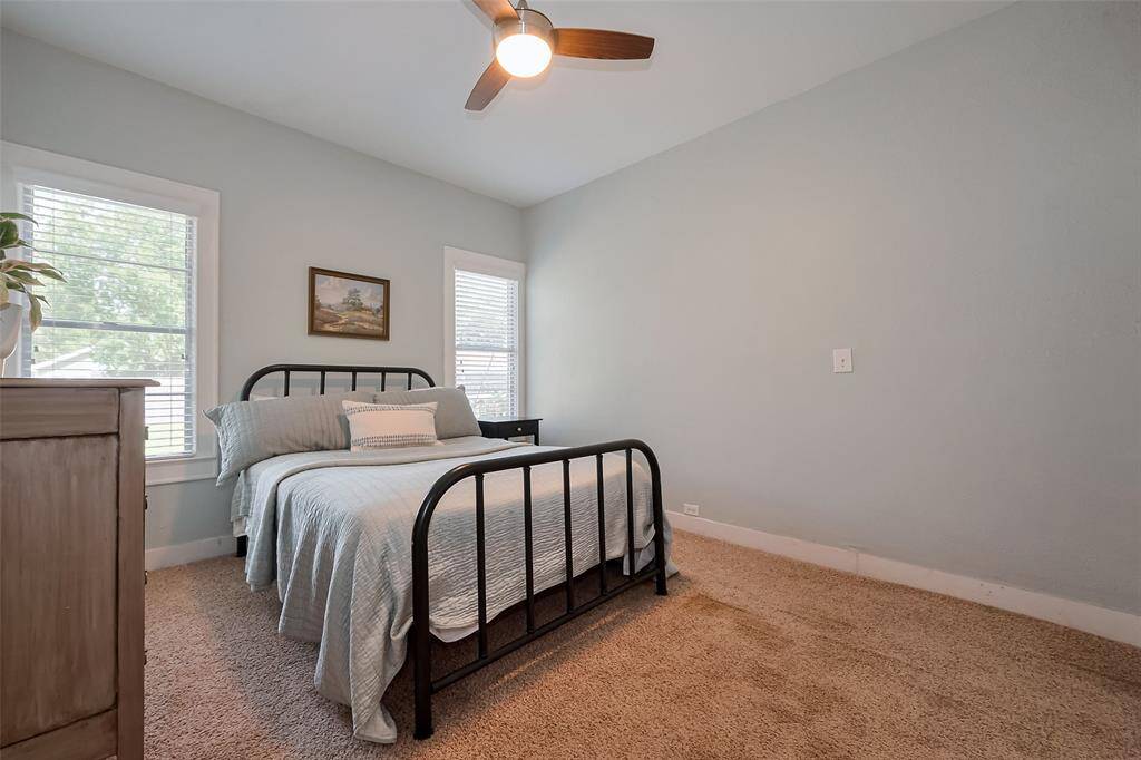 Cozy bedroom featuring a wood panel accent wall, with walls of windows that bring in plenty of natural light, creating a warm and inviting space.