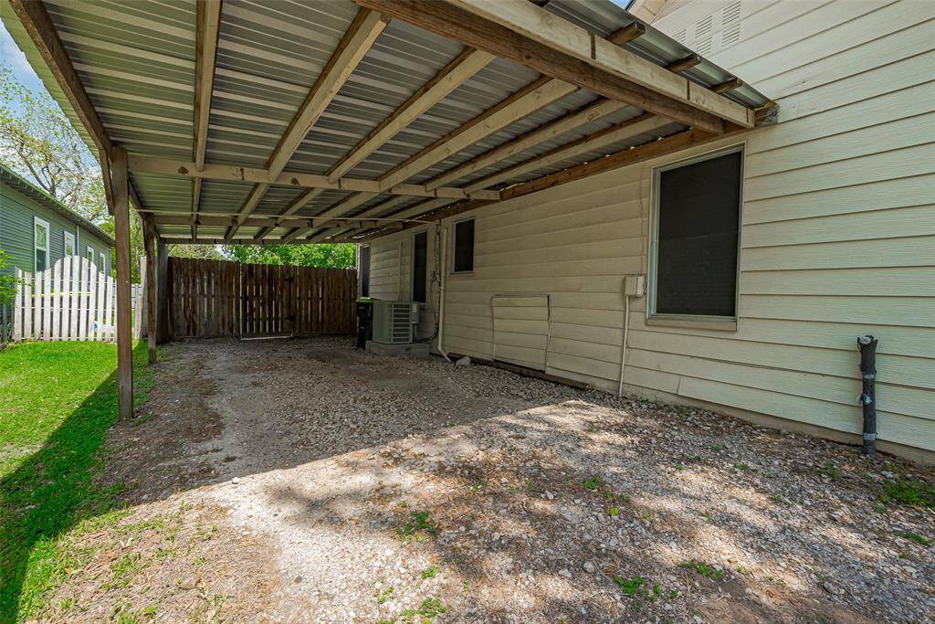 The carport offers convenient backyard access through a gate, providing easy entry to the spacious, fully fenced yard—perfect for outdoor activities.
