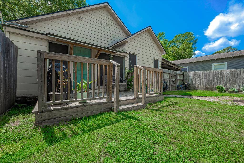 The spacious backyard features a charming wooden deck, ideal for outdoor dining, relaxation, or entertaining, with plenty of room to enjoy the outdoors in comfort.