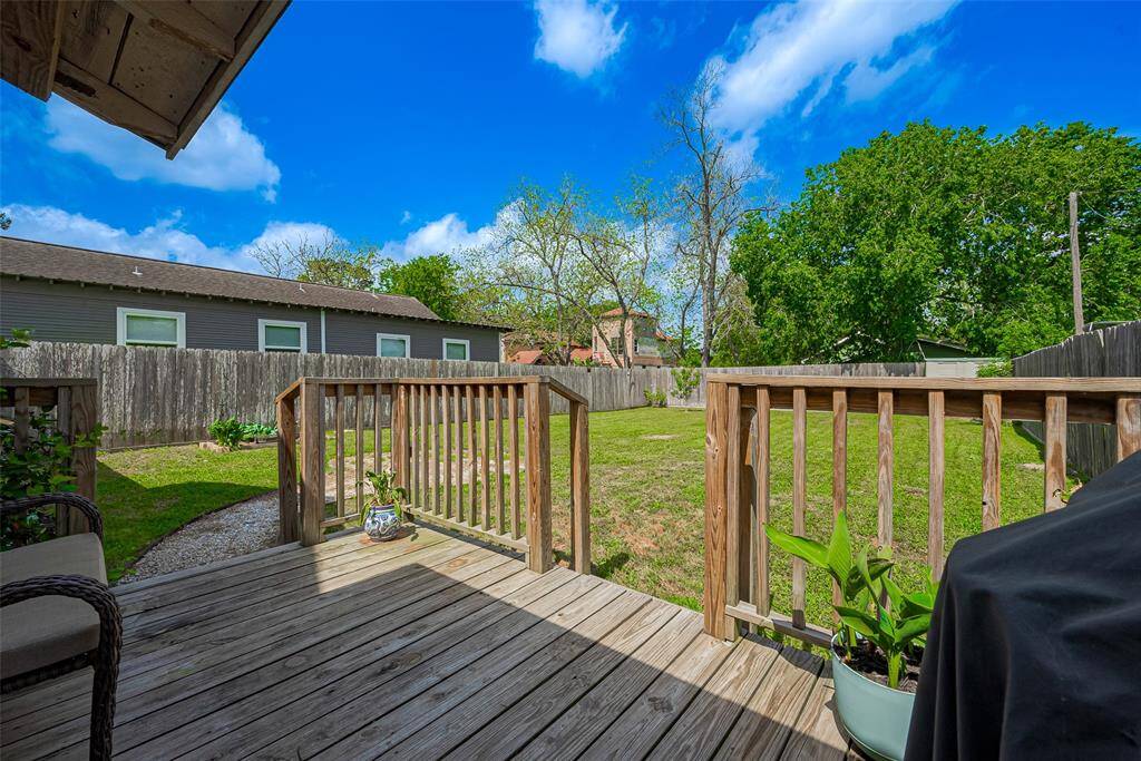 The spacious backyard features a charming wooden deck, ideal for outdoor dining, relaxation, or entertaining, with plenty of room to enjoy the outdoors in comfort.
