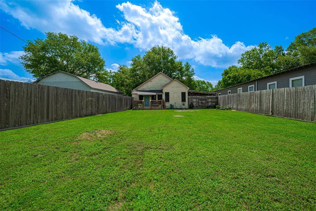 The spacious backyard features a charming wooden deck, ideal for outdoor dining, relaxation, or entertaining, with plenty of room to enjoy the outdoors in comfort.