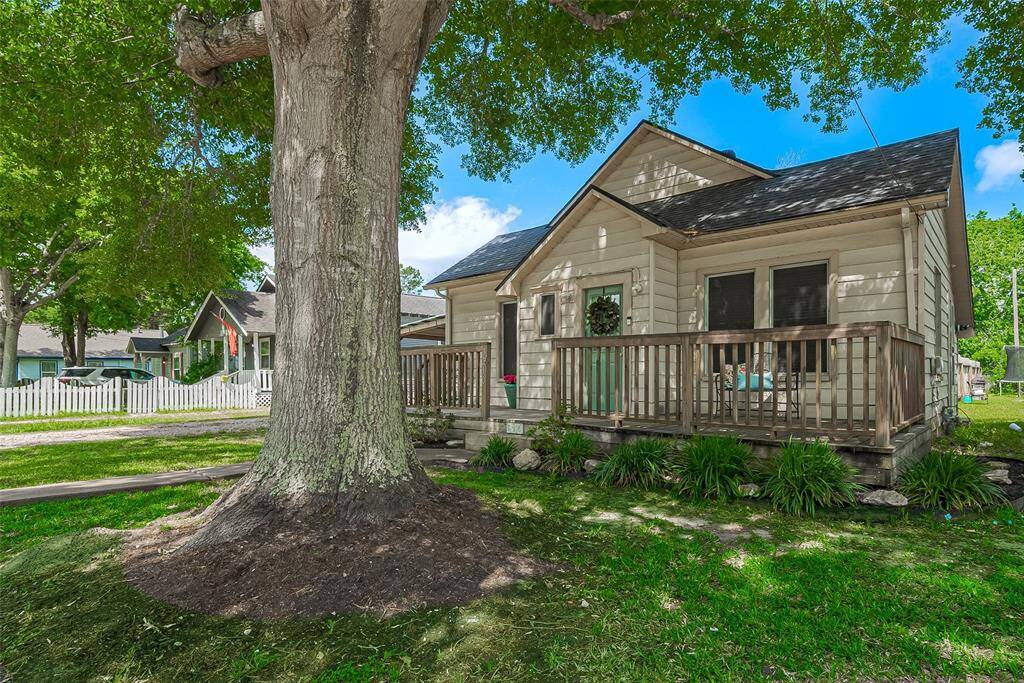 Charming single-story home with a cozy front porch, nestled under a large, mature tree. The well-maintained yard and inviting exterior offer great curb appeal in a peaceful neighborhood setting.